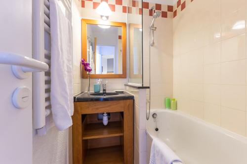 a bathroom with a sink and a bath tub at Résidence Pierre & Vacances Les Constellations in Belle Plagne