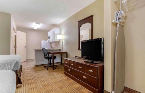 a hotel room with a bedroom with a television and a desk at Studio 6 Extended Stay Huntsville, AL - US Space & Rocket Center in Huntsville