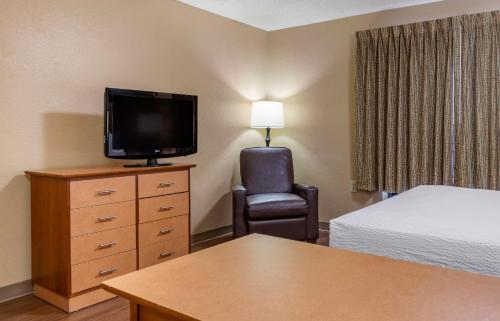 a hotel room with a bed and a tv and a chair at Extended Stay America Suites - San Antonio - Colonnade - Medical in San Antonio