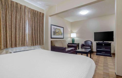 a hotel room with a bed and a flat screen tv at Extended Stay America Suites - Birmingham - Wildwood in Birmingham