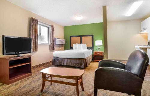 a hotel room with a bed and a flat screen tv at Studio 6 Suites Jackson Ridgeland MS in Ridgeland