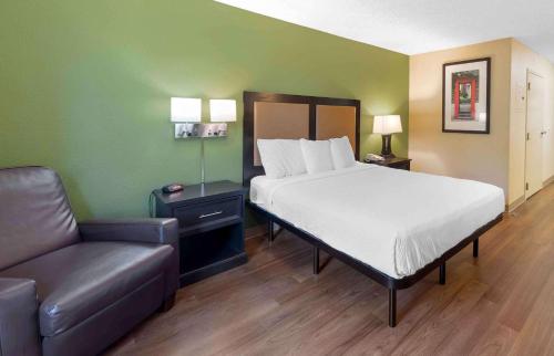 a bed and a couch in a room with a bed and a chair at Studio 6 Suites Jackson Ridgeland MS in Ridgeland