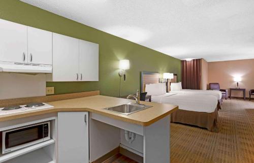 ein Hotelzimmer mit einem Bett und einer Küche mit einem Waschbecken in der Unterkunft Extended Stay America Suites - Houston - Med Ctr - Greenway Plaza in Houston