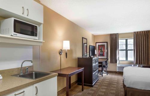 a hotel room with a bed and a kitchen with a sink at Extended Stay America Suites - Boise - Airport in Boise