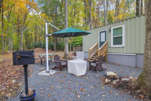 a patio with a table and an umbrella next to a house at Camptel Poconos in Albrightsville