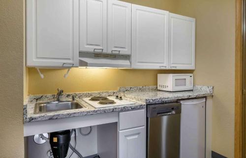 a kitchen with white cabinets and a sink and a microwave at Extended Stay America Suites - Seattle - Bothell - Canyon Park in Bothell