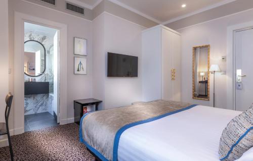a hotel room with a bed and a television at Hôtel Du Bois Champs-Elysées in Paris
