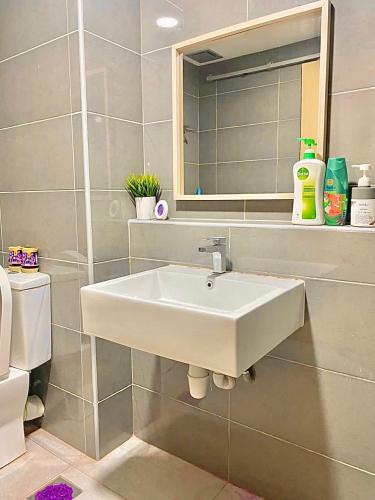 a bathroom with a white sink and a mirror at imperium residence kuantan in Kuantan