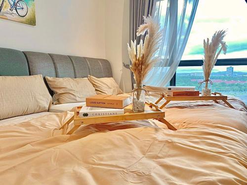 two tables with books on top of a bed at imperium residence kuantan in Kuantan