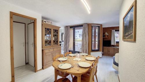 une salle à manger avec une table et des chaises en bois dans l'établissement Christiana 5, à Saint-Jean-dʼAulps