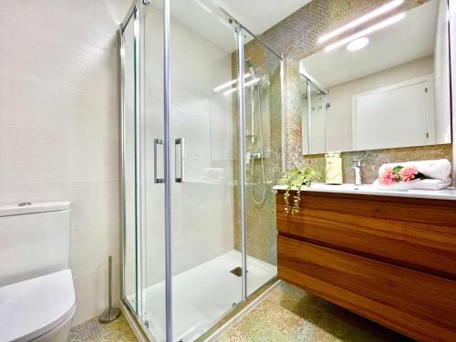 een badkamer met een glazen douche en een toilet bij Chaves House by Gloove in Santa Pola