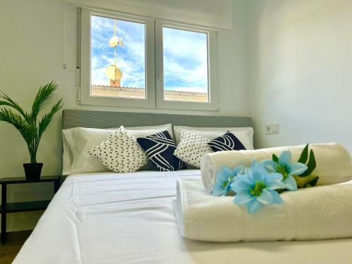 een slaapkamer met een wit bed met blauwe bloemen erop bij Chaves House by Gloove in Santa Pola