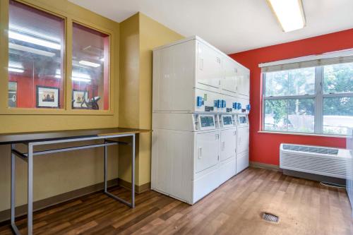 a kitchen with a white refrigerator and red walls at Extended Stay America Suites - Seattle - Everett - Silverlake in Murphys Corner