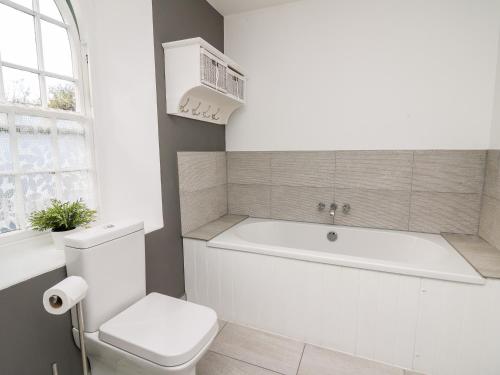 uma casa de banho com uma banheira, um WC e uma janela. em Upper Vestry em Llandysul