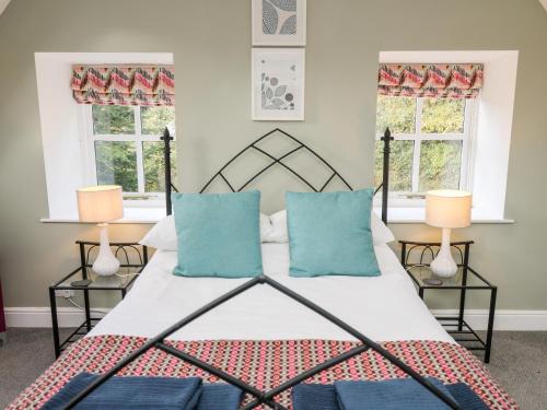 um quarto com uma cama com almofadas azuis em Upper Vestry em Llandysul