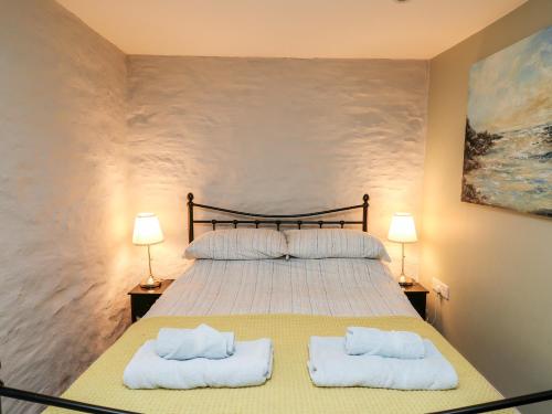 a bedroom with a large bed with two white towels at Lower Vestry in Llandysul
