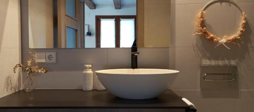 a bathroom with a bowl sink and a mirror at Altxabi Apartamento Rural in Ochagavía