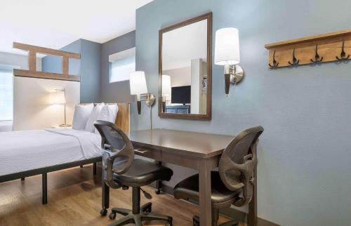 a bedroom with a desk and a bed and a mirror at Extended Stay America Suites - Seattle - Redmond in Bellevue