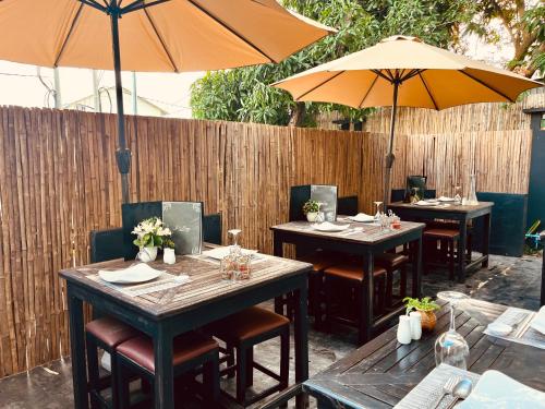 two tables and two umbrellas on a patio at Prana Hotel in Siem Reap
