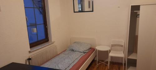 ゲッピンゲンにあるMonteur Zimmer - Göppingenのベッドと窓が備わる小さな客室です。