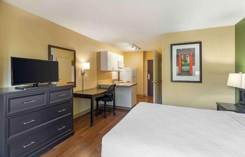 a hotel room with a bed and a desk with a television at Extended Stay America Suites - Denver - Park Meadows in Lone Tree