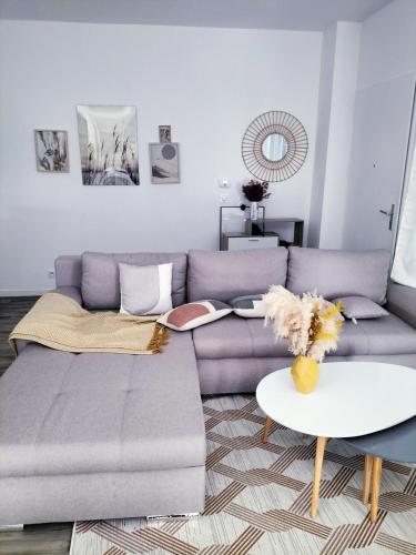 ein Wohnzimmer mit einem Sofa und einem Tisch in der Unterkunft Grande Chambre Neuve Parking prive Cergy RER in Cergy