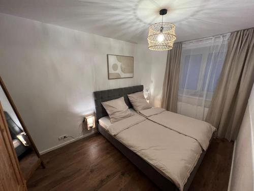 una piccola camera da letto con un letto e un lampadario a braccio di Wohnen im Herzen von Sonthofen a Sonthofen
