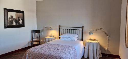 a bedroom with a bed and two tables with lamps at Casa Garcia in Amareleja