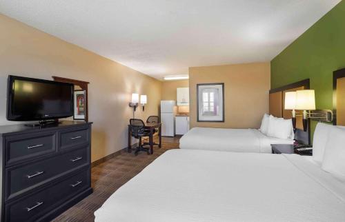 a hotel room with two beds and a flat screen tv at Extended Stay America Suites - Nashville - Brentwood - South in Brentwood