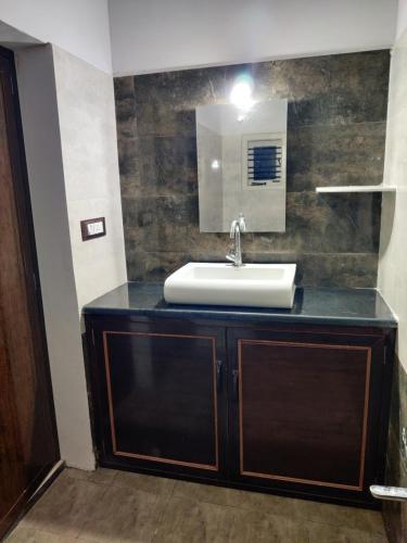 y baño con lavabo y espejo. en Single haven 8431o31389 en Mysore