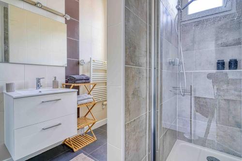 een badkamer met een douche en een wastafel bij Appartement dans résidence calme, proche de Paris in La Garenne-Colombes