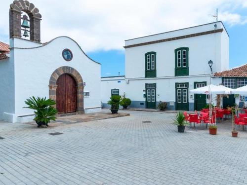 a white building with a large door and a courtyard at Live Arico Lagar in Arico el Nuevo