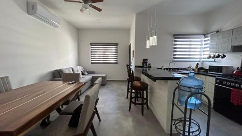 a kitchen and living room with a wooden table and a dining room at Casa Relax w/Pool & Rooftop Lounge in El Centenario
