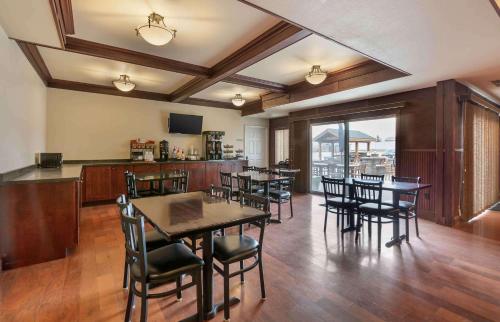 a dining room with tables and chairs and a kitchen at Extended Stay Americas Suites - Minot in Minot