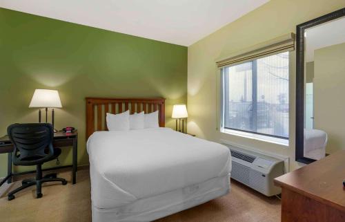 a bedroom with a bed and a desk and a window at Extended Stay Americas Suites - Minot in Minot