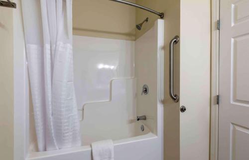 a bathroom with a shower and a white shower curtain at Extended Stay Americas Suites - Minot in Minot