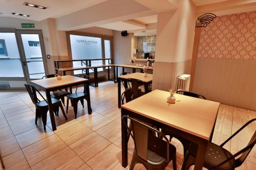 a restaurant with tables and chairs in a room at Hotel Tierra Gaucha in San Carlos de Bariloche