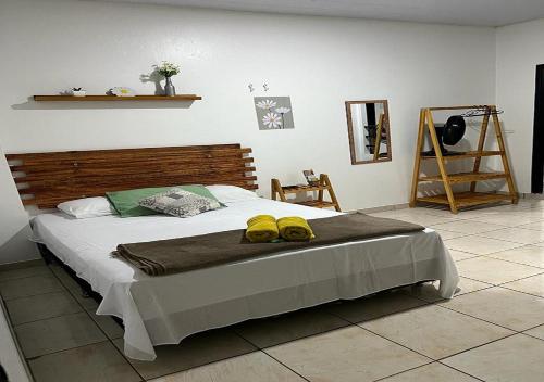 Un dormitorio con una cama con dos zapatos amarillos. en Residencial Margarida APART 1 en Presidente Figueiredo