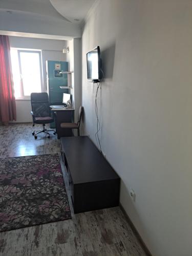 a room with a desk and a tv on a wall at Apartament in Chişinău