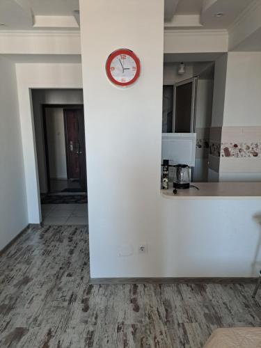 a clock on a white wall in a kitchen at Apartament in Chişinău