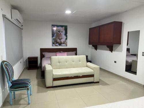 COOL HOUSE 24Horas في أراوكا: غرفة نوم مع أريكة بيضاء وسرير