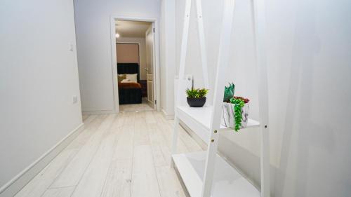 - un couloir avec des murs et des sols blancs dans l'établissement "E2M Royal Penthouse Luxurious Retreat in Slough", à Slough