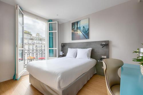 a bedroom with a large bed and a large window at Hotel de France Invalides in Paris