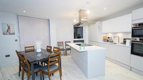 a kitchen and dining room with a table and chairs at "Easy 2 Manage Royal Penthouse Luxurious Retreat in Slough" in Slough