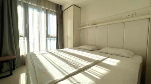 a bedroom with a white bed and a large window at Sunraf Luxe Apartments in Budva