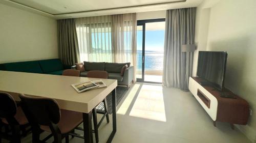 a living room with a couch and a table and a television at Sunraf Luxe Apartments in Budva