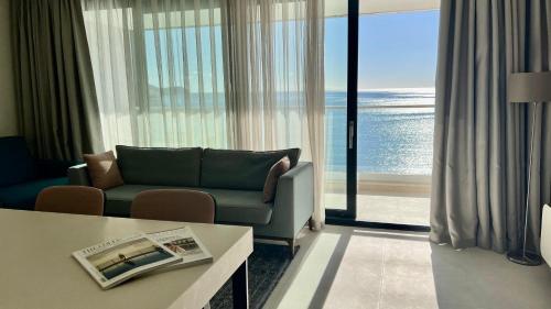 a living room with a couch and a view of the ocean at Sunraf Luxe Apartments in Budva