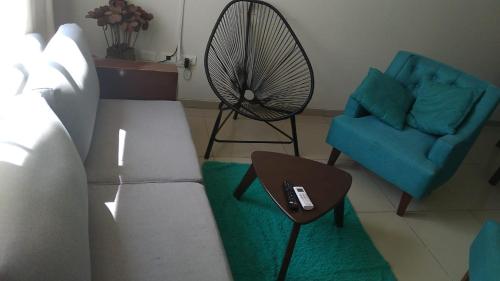 uma sala de estar com um sofá, uma cadeira e uma ventoinha em Casa Elegante, Cómoda y Relax em Santa Cruz de la Sierra