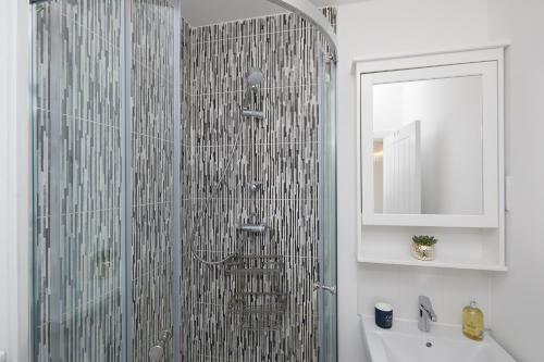 a bathroom with a shower with a sink and a mirror at Derby Train Station Roof Terrace House in Derby