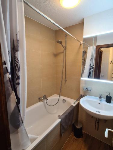 a bathroom with a tub and a sink and a shower at Greppons N 012 - MOUNTAIN apartment 6 pers in Veysonnaz